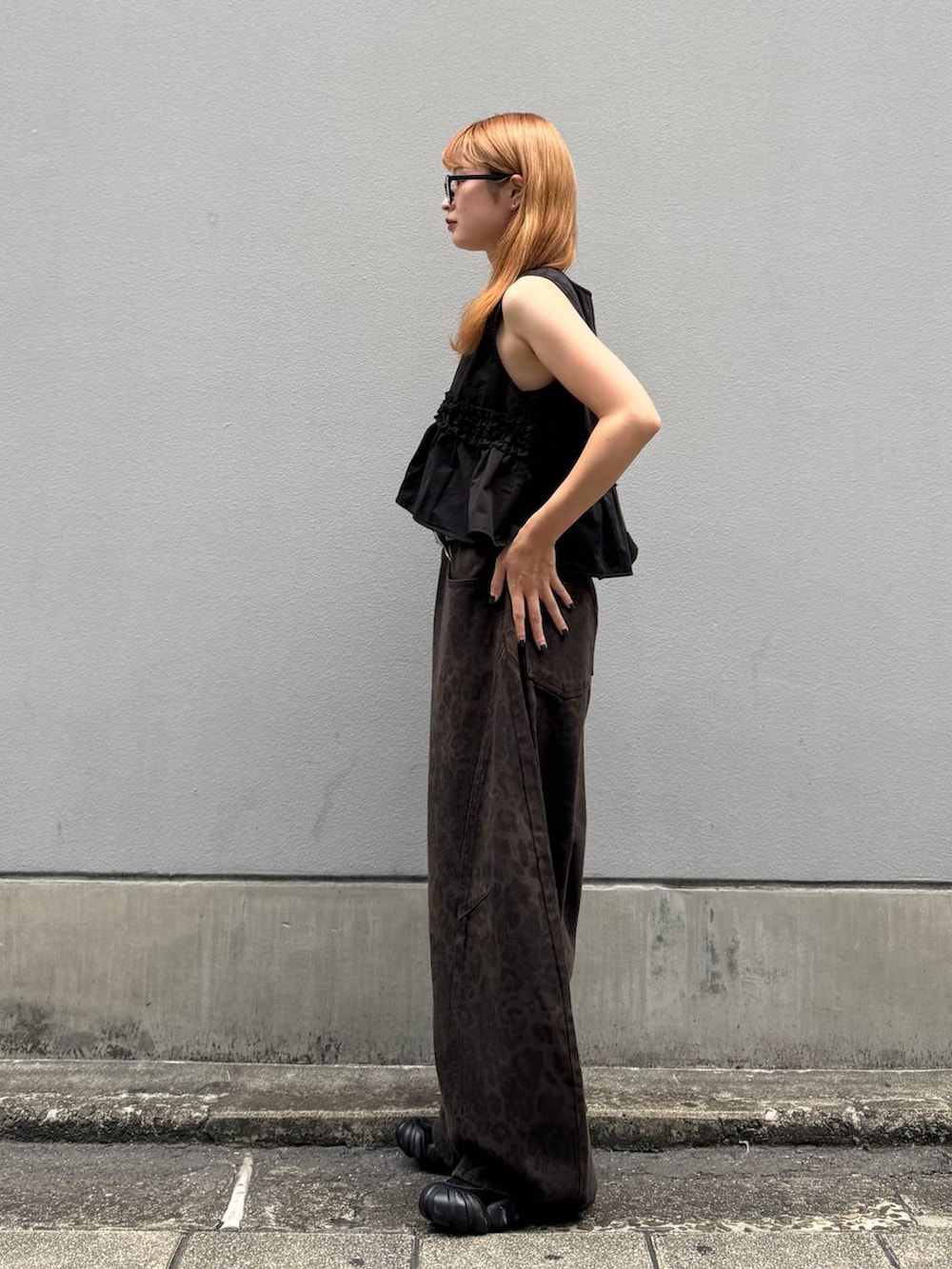 ブラウン系のデニムパンツ、ブラック系のベスト、ブラック系のベルトを着用したレディースの夏コーディネートの6枚目の写真