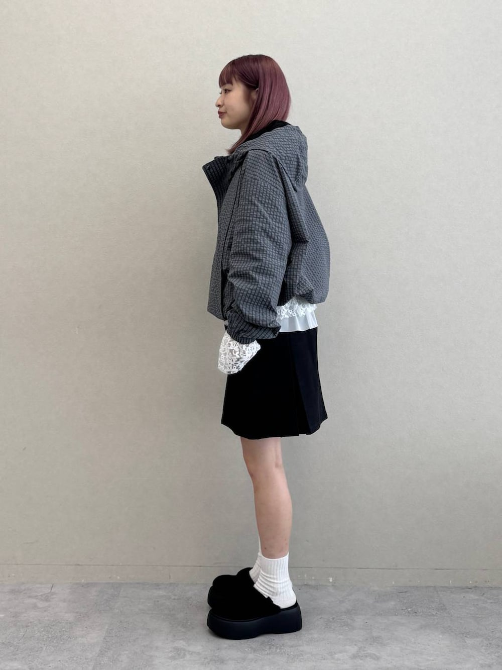 ホワイト系のTシャツ/カットソー、ブラック系のスカート、グレー系のブルゾンを着用したレディースの秋コーディネートの5枚目の写真