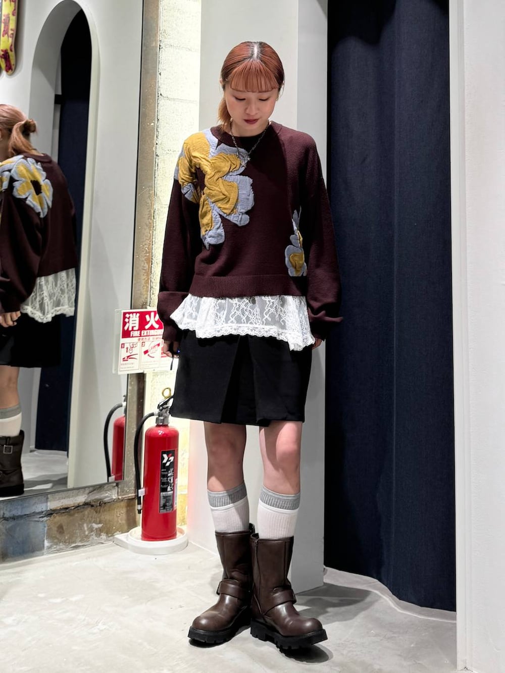 ホワイト系のTシャツ/カットソー、ブラウン系のニット/セーター、ブラック系のスカートを着用したレディースの秋コーディネートの3枚目の写真