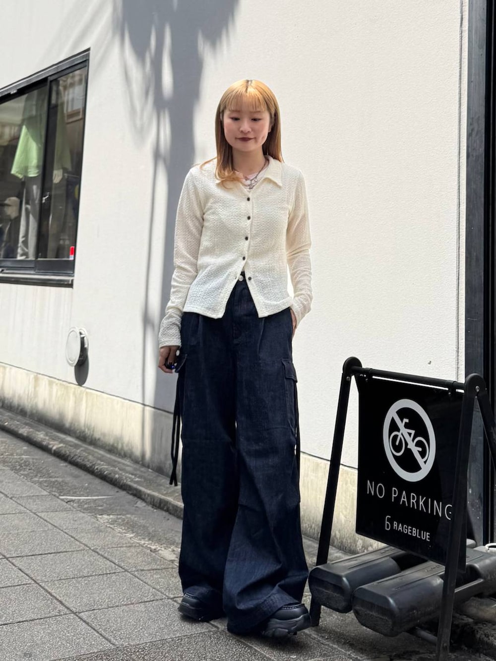 ブラック系のローファー、ブルー系のデニムパンツ、ホワイト系のカーディガン/ボレロを着用したレディースの春コーディネートの3枚目の写真