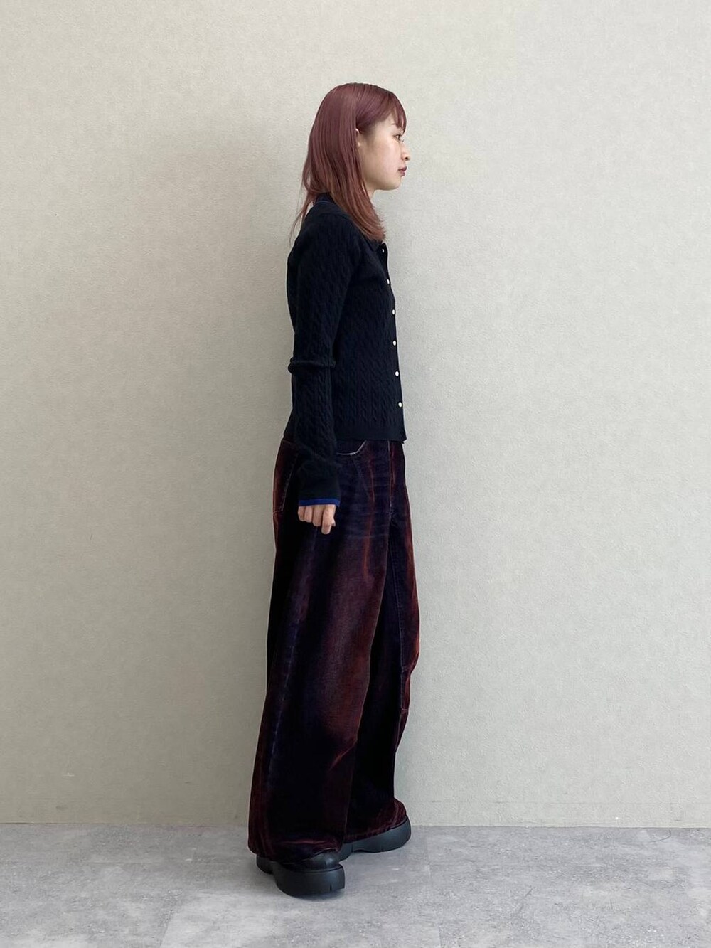 レッド系のデニムパンツ、ブラック系のニット/セーターを着用したレディースの秋コーディネートの7枚目の写真