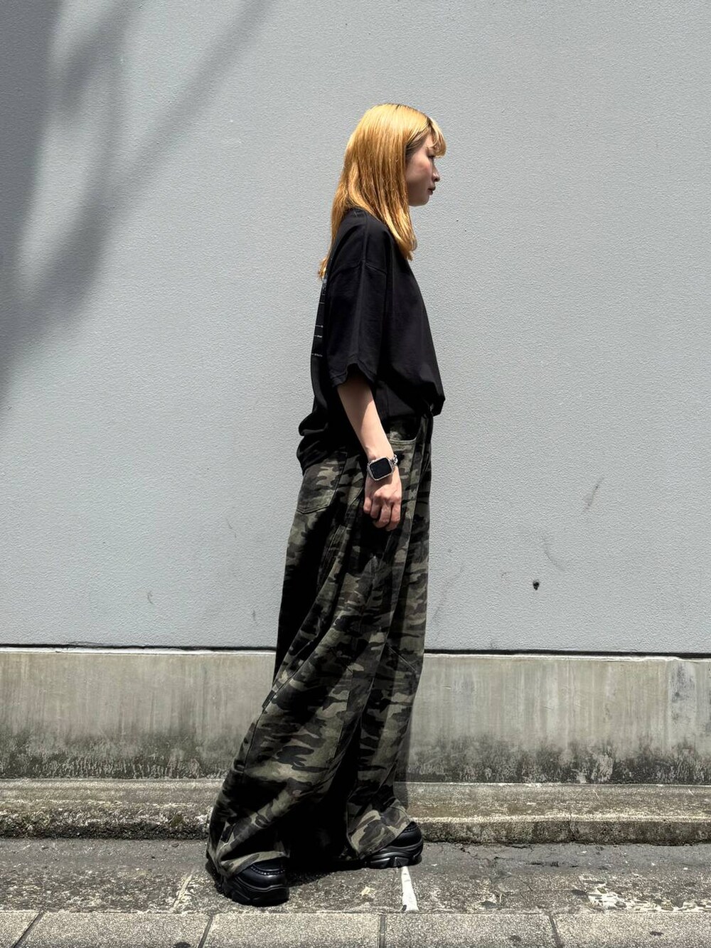 ブラック系のローファー、ブラック系のTシャツ/カットソー、グリーン系のデニムパンツを着用したレディースの春コーディネートの6枚目の写真