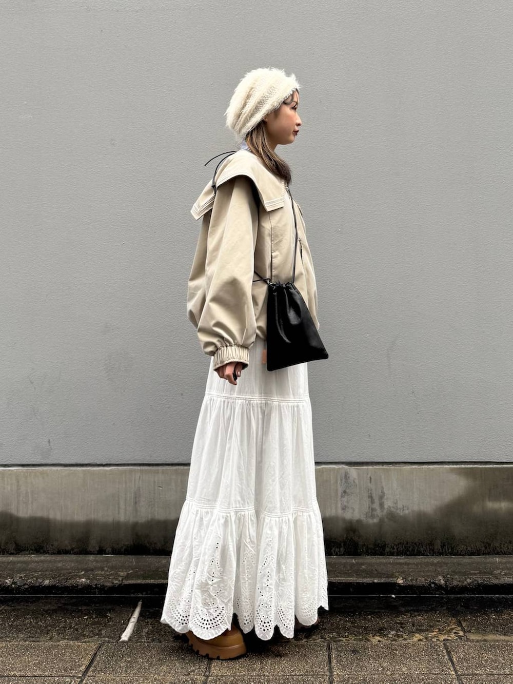 ブラック系のショルダーバッグ、ベージュ系のブルゾン、ブルー系のシャツ/ブラウスを着用したレディースの春コーディネートの6枚目の写真