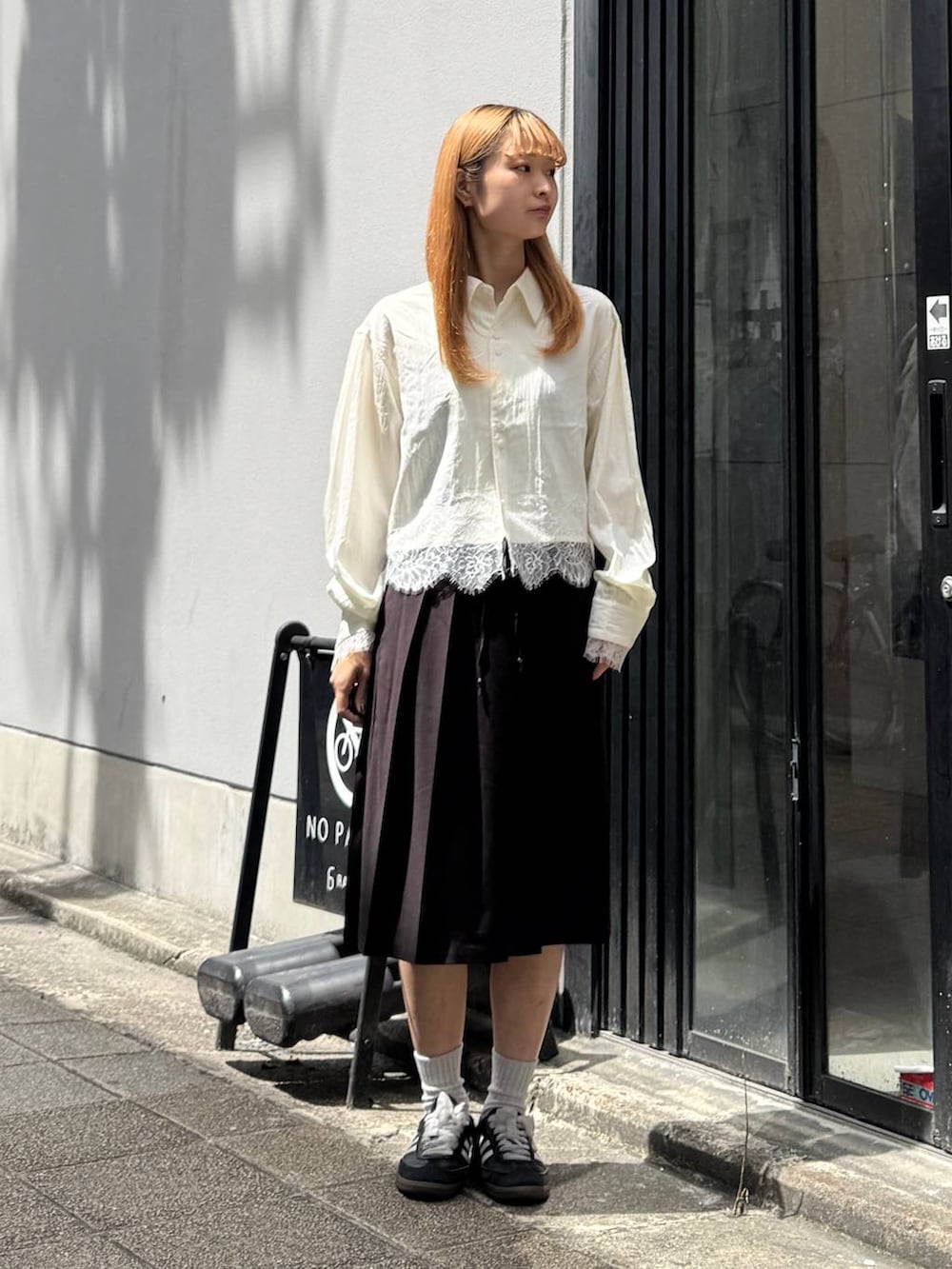 ブラウン系のスカート、ホワイト系のシャツ/ブラウスを着用したレディースの夏コーディネートの3枚目の写真