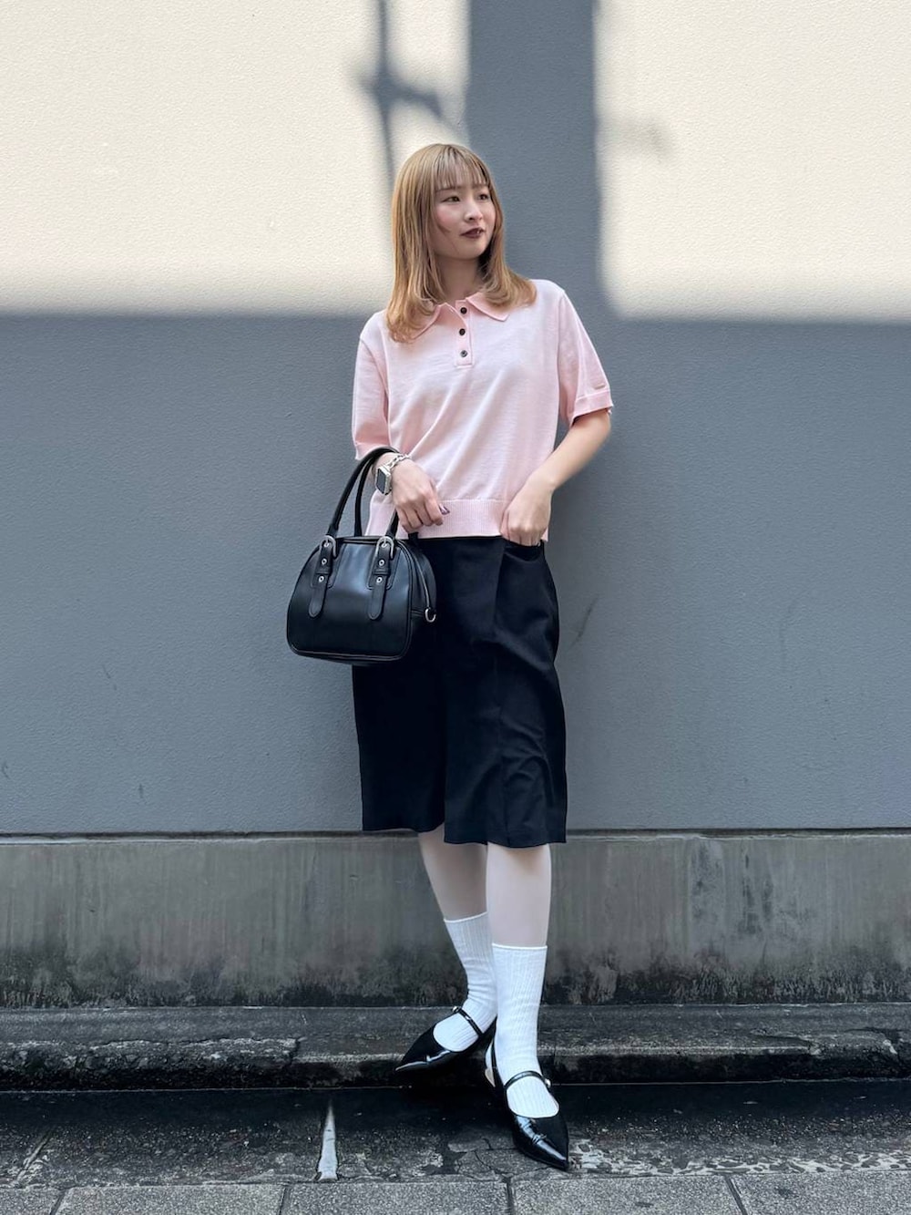 ブラック系のパンプス、ブラック系のスラックス、ブラック系のボストンバッグを着用したレディースの春コーディネートの3枚目の写真