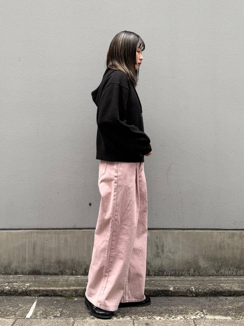 ピンク系のデニムパンツ、ブラック系のニット/セーターを着用したレディースの春コーディネートの7枚目の写真