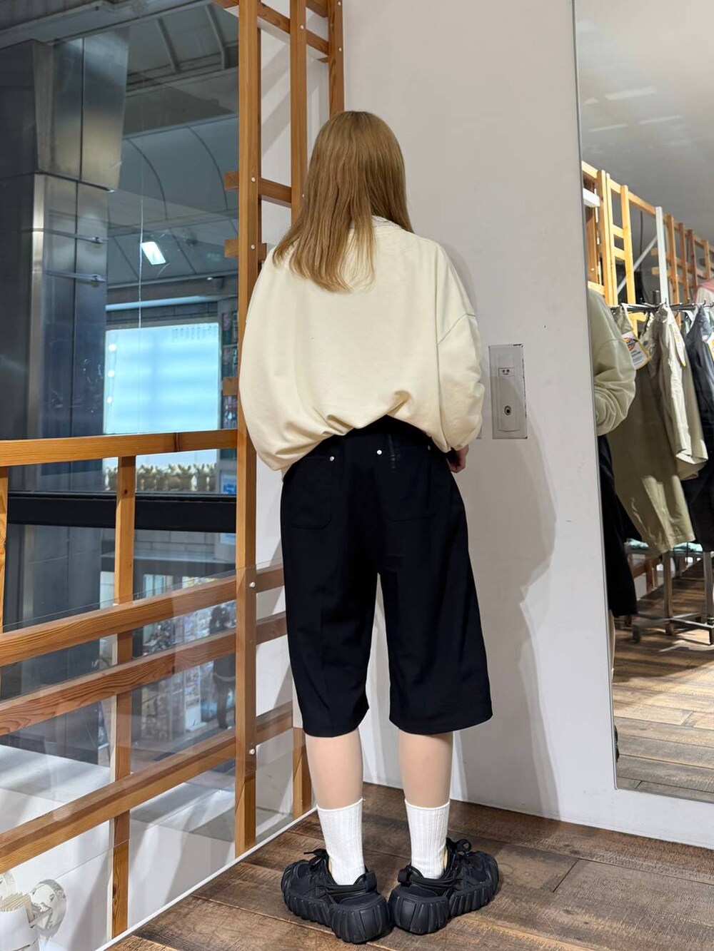 ホワイト系のスウェット、ブラック系のスラックスを着用したレディースの春コーディネートの6枚目の写真