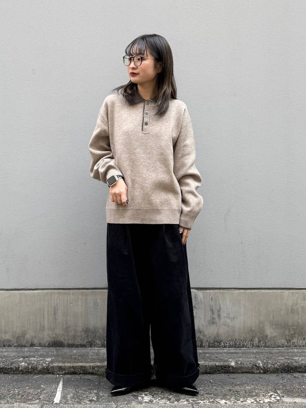 ブラック系のパンプス、ブラック系のチノパンツ、ベージュ系のニット/セーターを着用したレディースの春コーディネートの3枚目の写真