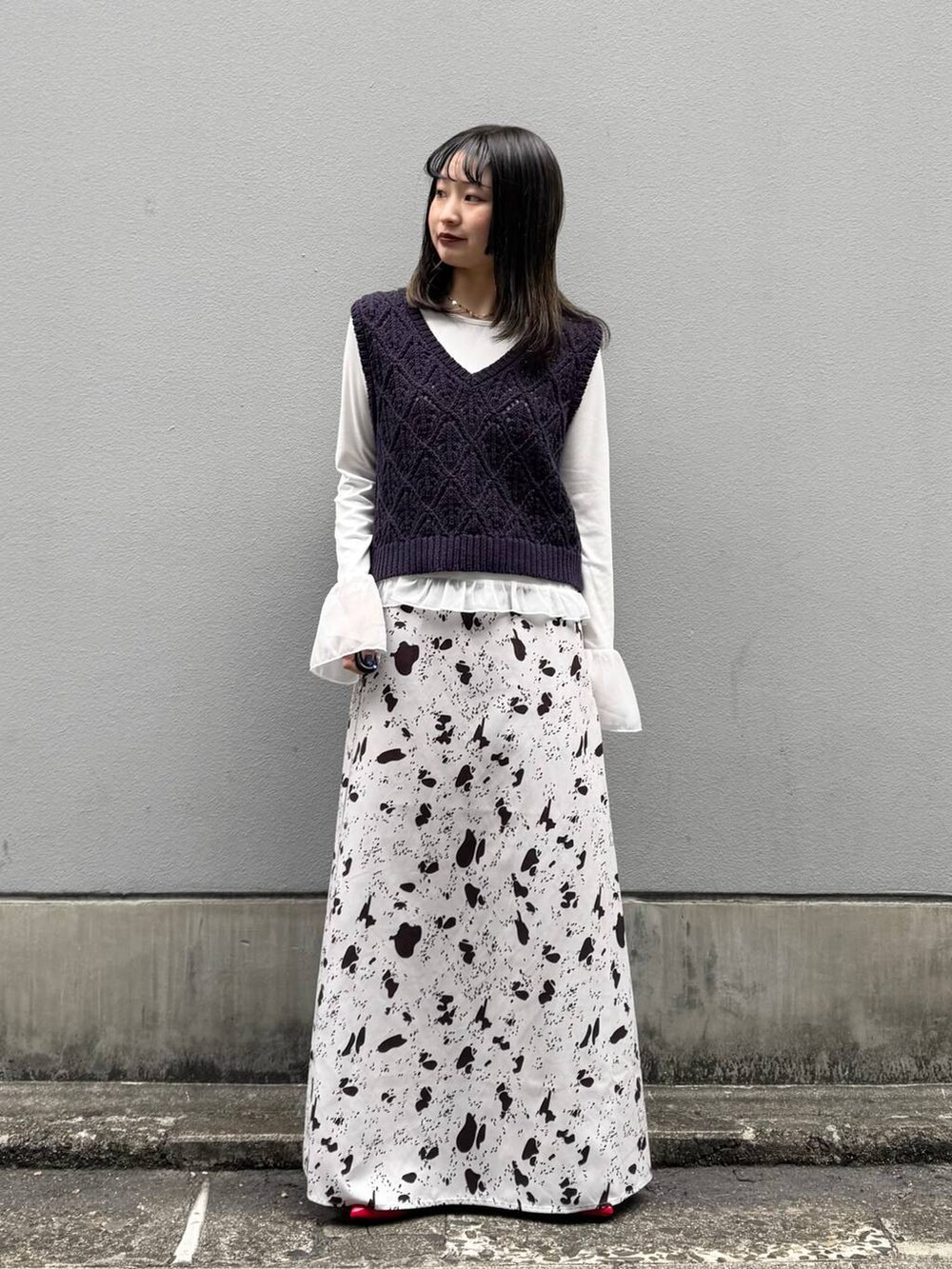 レッド系のパンプス、ブラウン系のスカート、ホワイト系のTシャツ/カットソーを着用したレディースの春コーディネートの4枚目の写真