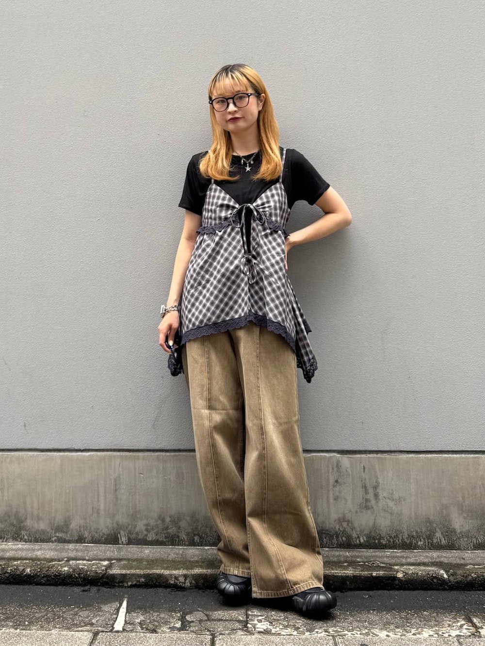 ブラック系のTシャツ/カットソー、ブラウン系のデニムパンツ、ホワイト系のキャミソールを着用したレディースの夏コーディネートの2枚目の写真