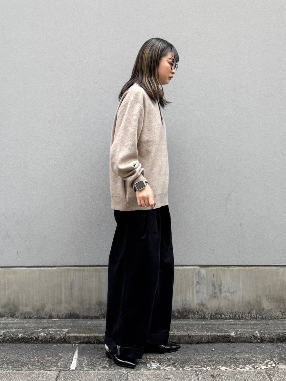 ブラック系のパンプス、ブラック系のチノパンツ、ベージュ系のニット/セーターを着用したレディースの春コーディネートの7枚目の写真