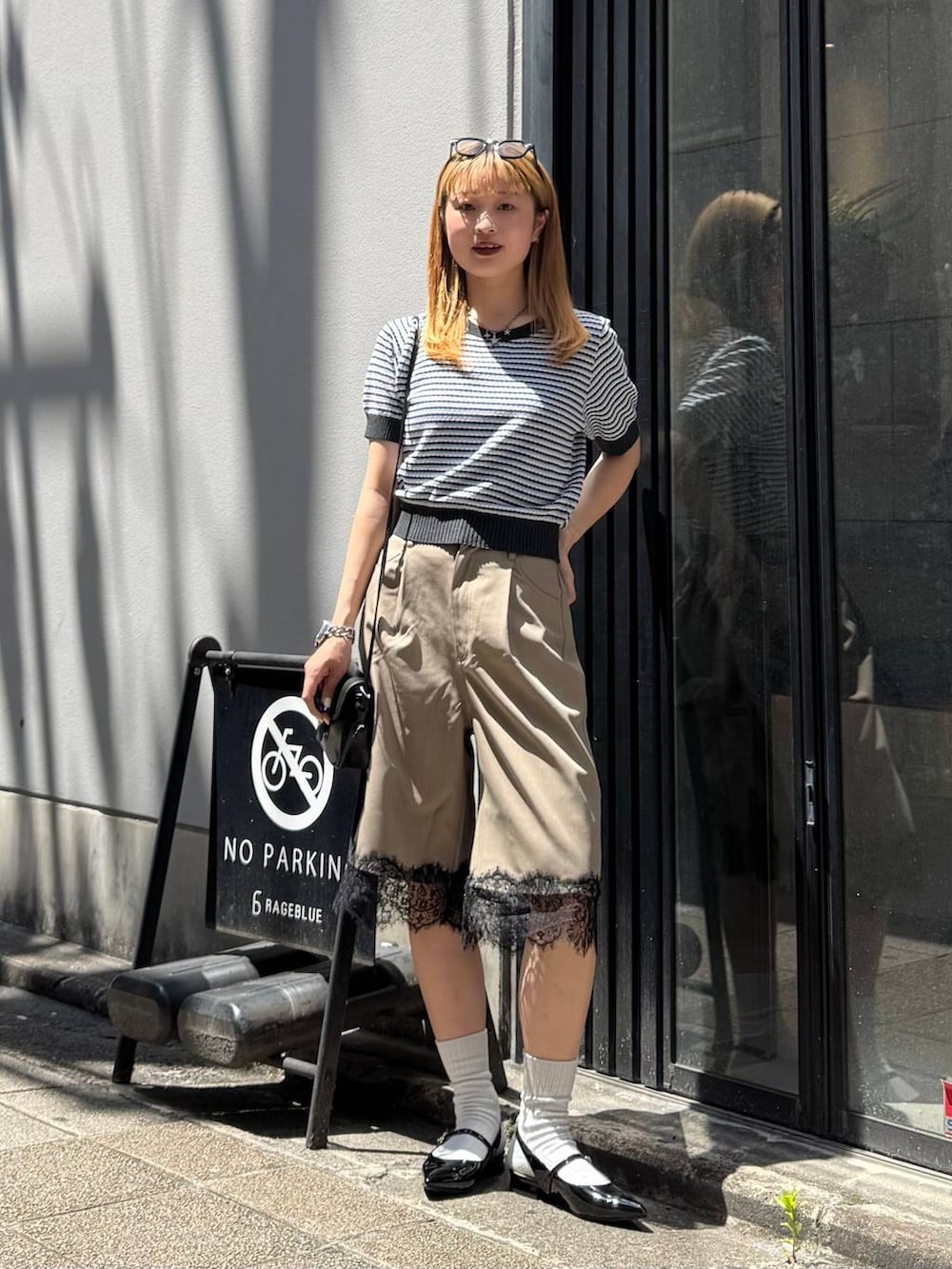 ブラック系のパンプス、グレー系のニット/セーター、ブラック系のショルダーバッグを着用したレディースの春コーディネートの3枚目の写真
