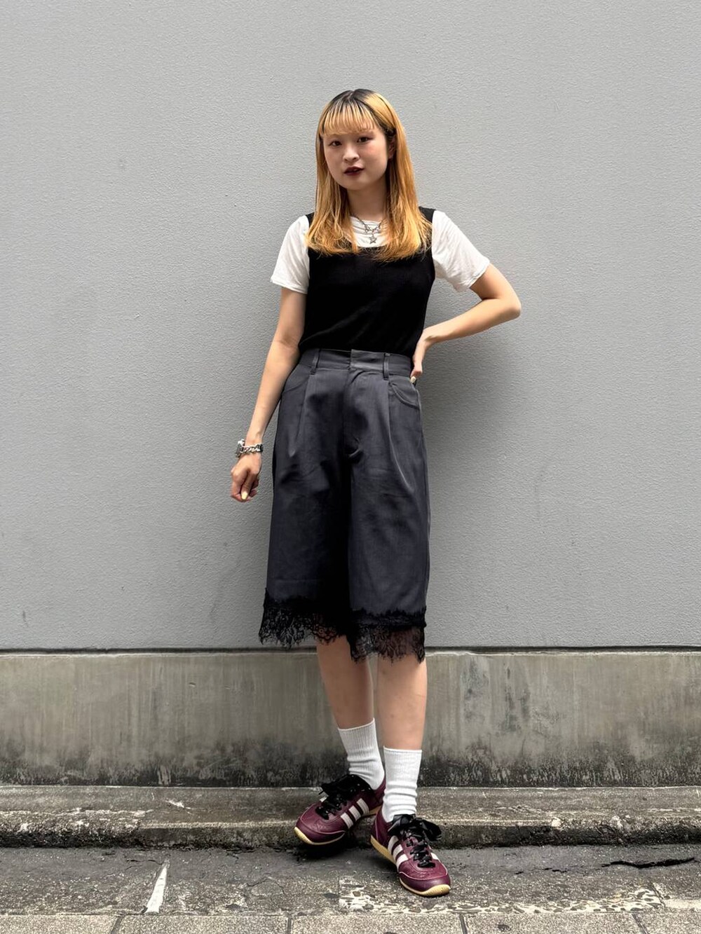 ブラック系のタンクトップ、ホワイト系のTシャツ/カットソー、ブラック系のスラックスを着用したレディースの夏コーディネートの4枚目の写真