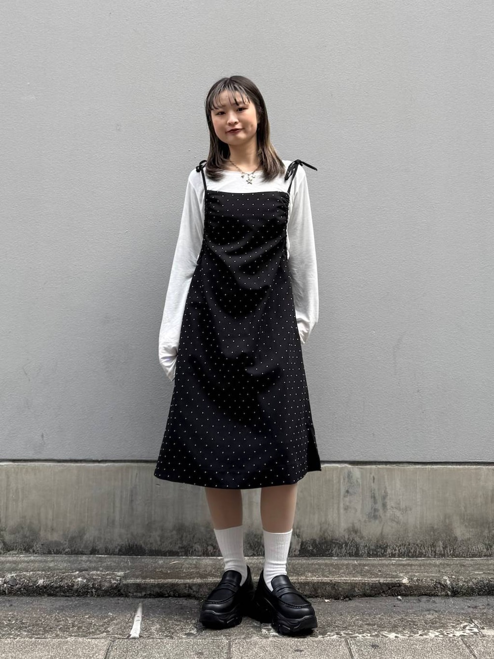 ブラック系のローファー、ブラック系のワンピース、ホワイト系のTシャツ/カットソーを着用したレディースの春コーディネートの8枚目の写真