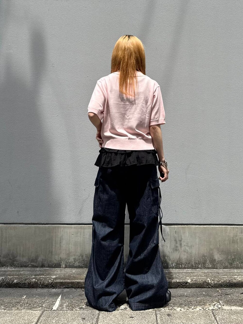 ピンク系のポロシャツ、ブルー系のデニムパンツ、グレー系のタンクトップを着用したレディースの夏コーディネートの6枚目の写真