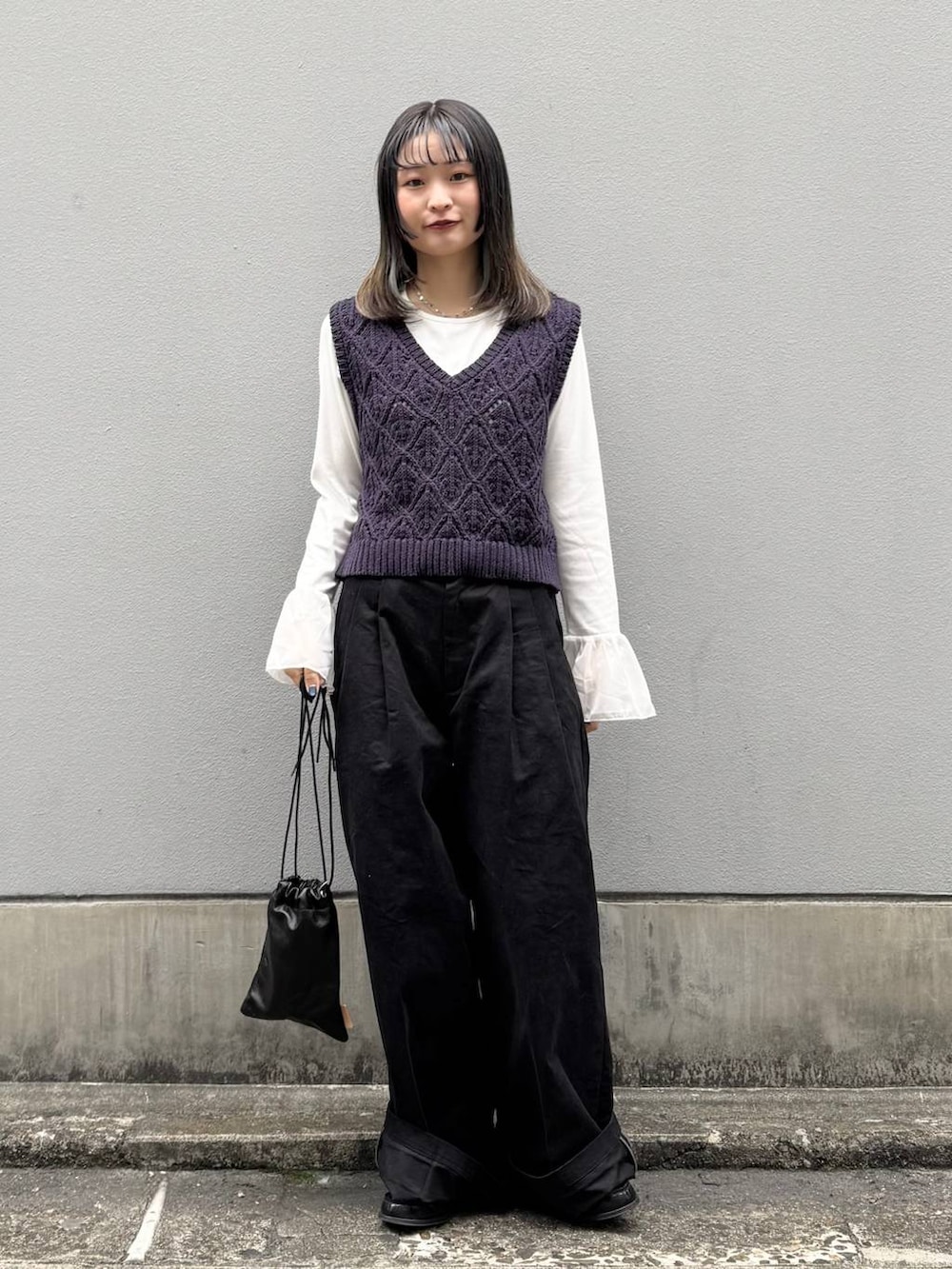 ブラック系のショルダーバッグ、ブラック系のチノパンツ、ホワイト系のTシャツ/カットソーを着用したレディースの春コーディネートの4枚目の写真