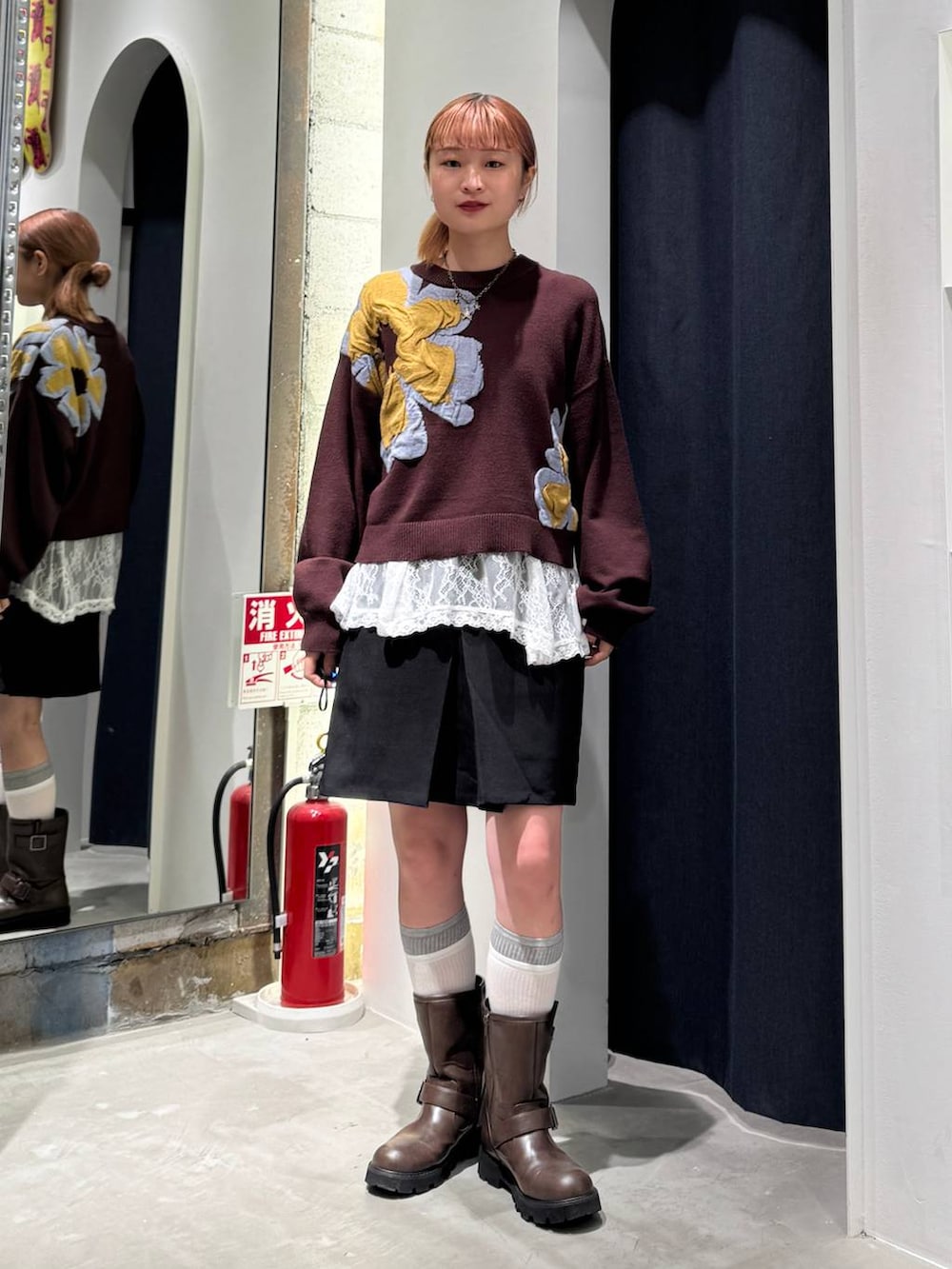 ホワイト系のTシャツ/カットソー、ブラウン系のニット/セーター、ブラック系のスカートを着用したレディースの秋コーディネートの2枚目の写真