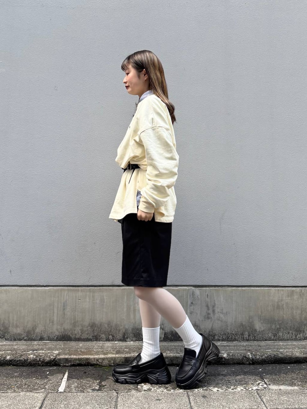 ブラック系のローファー、ブラック系のスラックス、ブルー系のシャツ/ブラウスを着用したレディースの春コーディネートの5枚目の写真