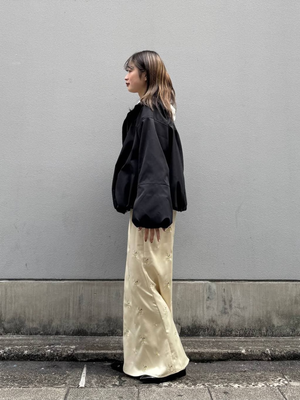 ブラック系のパンプス、ホワイト系のパーカー、ブラック系のブルゾンを着用したレディースの春コーディネートの4枚目の写真