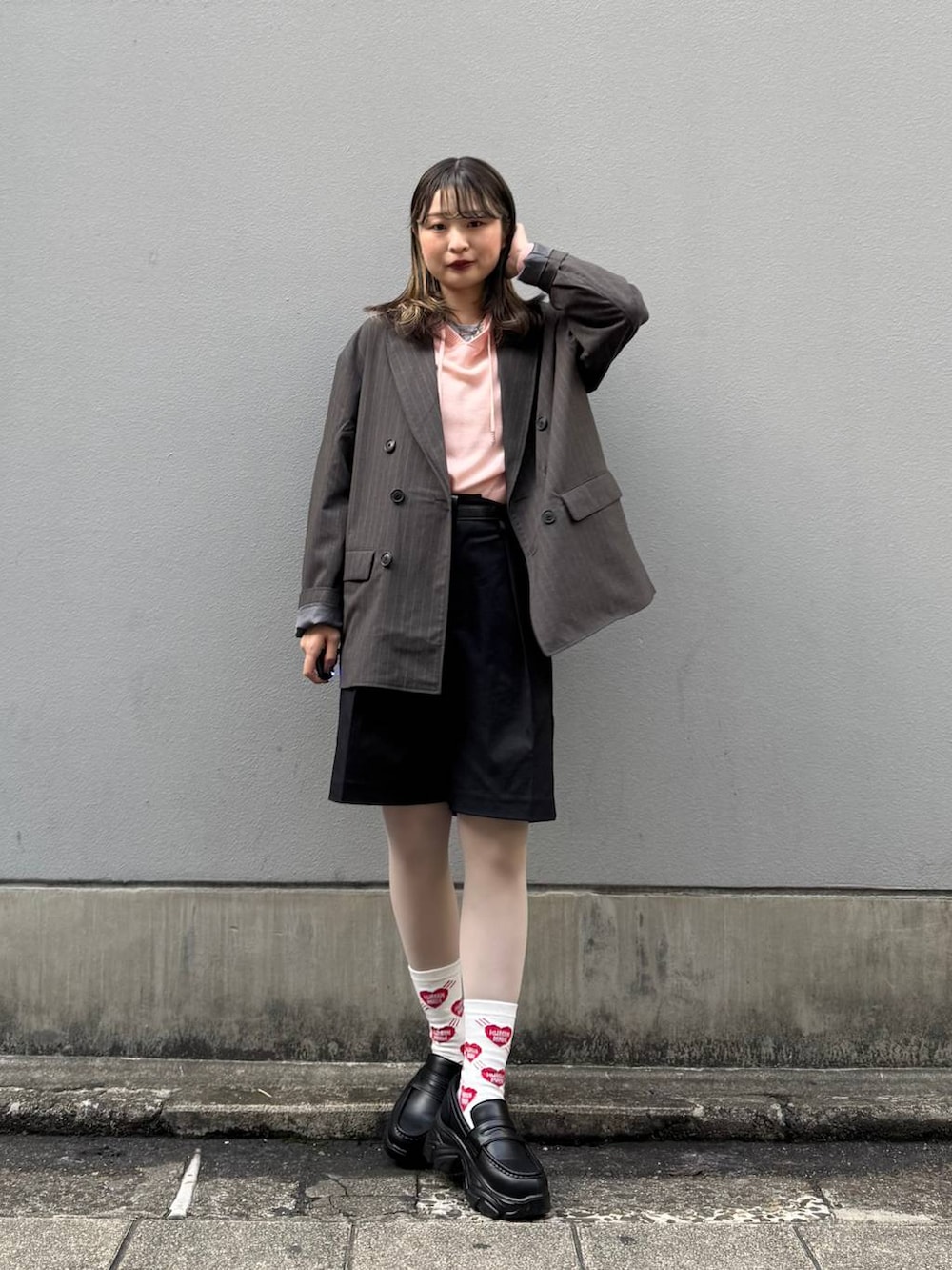 ブラック系のテーラードジャケット、ブラック系のローファー、ブラック系のスラックスを着用したレディースの春コーディネートの2枚目の写真