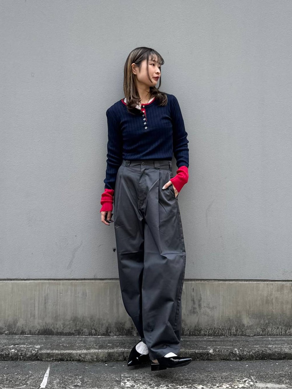 グレー系のチノパンツ、ブラック系のパンプス、ブルー系のニット/セーターを着用したレディースの春コーディネートの3枚目の写真
