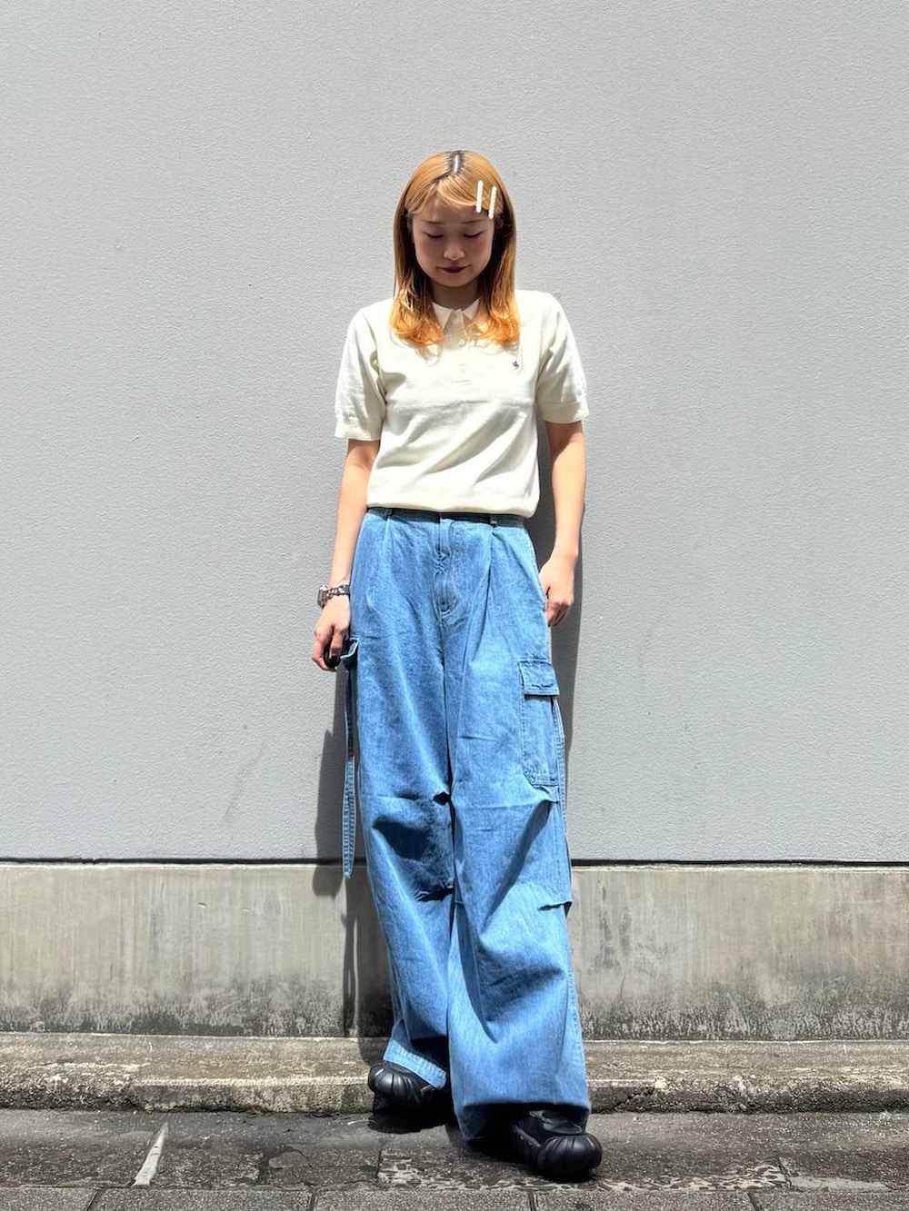 ブルー系のデニムパンツ、ホワイト系のポロシャツを着用したレディースの春コーディネートの4枚目の写真