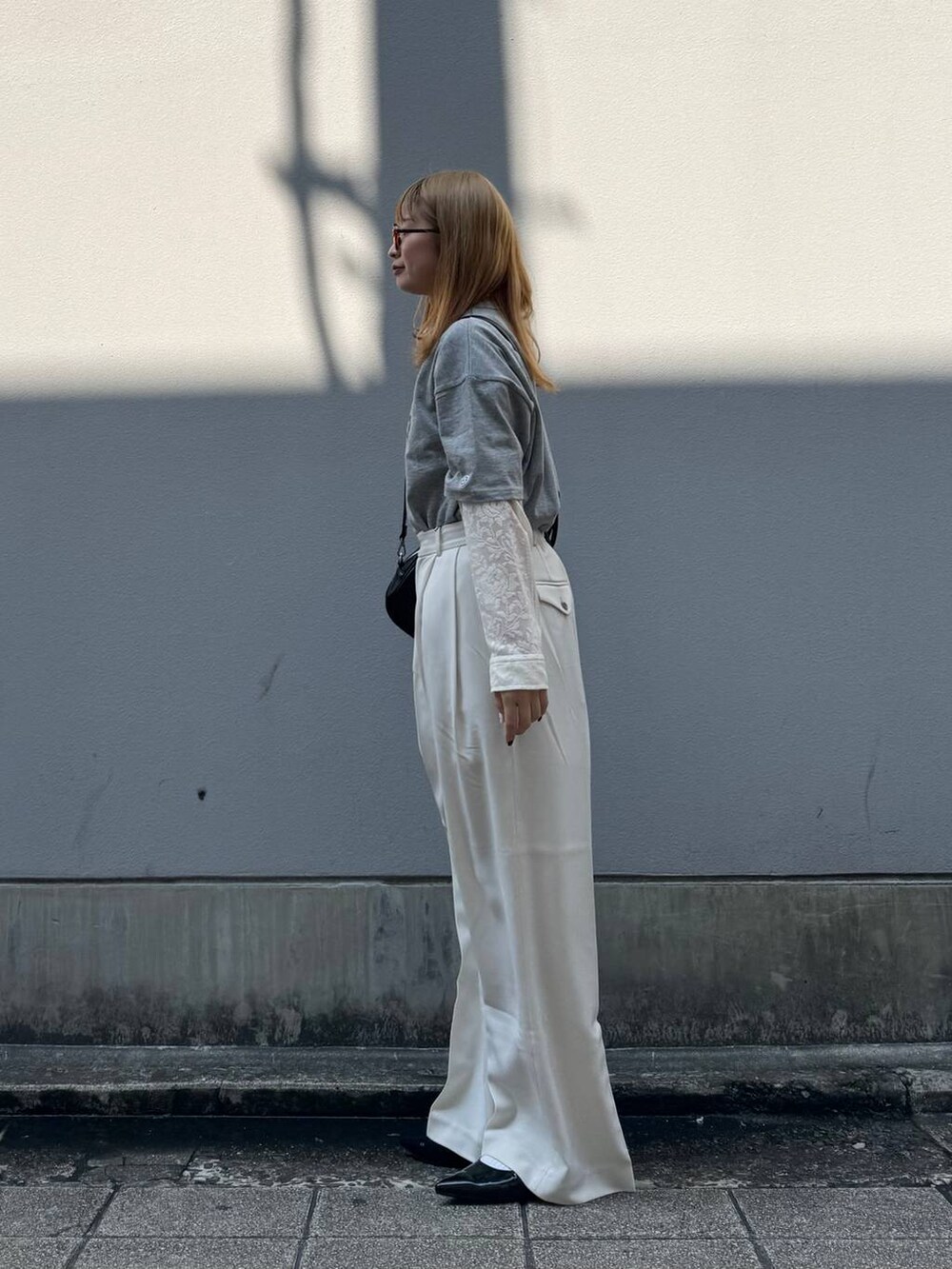 グレー系のTシャツ/カットソー、ブラック系のパンプス、ホワイト系のシャツ/ブラウスを着用したレディースの春コーディネートの5枚目の写真