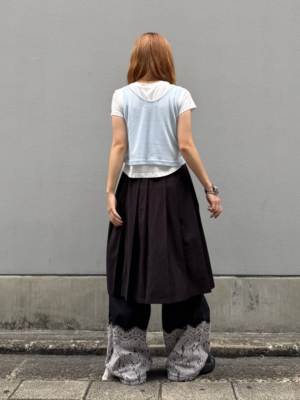 ブラウン系のスカート、ブラック系のデニムパンツ、ホワイト系のTシャツ/カットソーを着用したレディースの秋コーディネートの7枚目の写真