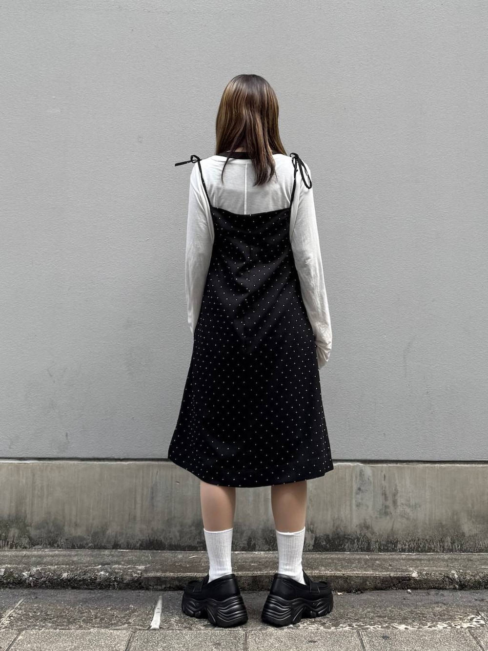 ブラック系のローファー、ブラック系のワンピース、ホワイト系のTシャツ/カットソーを着用したレディースの春コーディネートの6枚目の写真