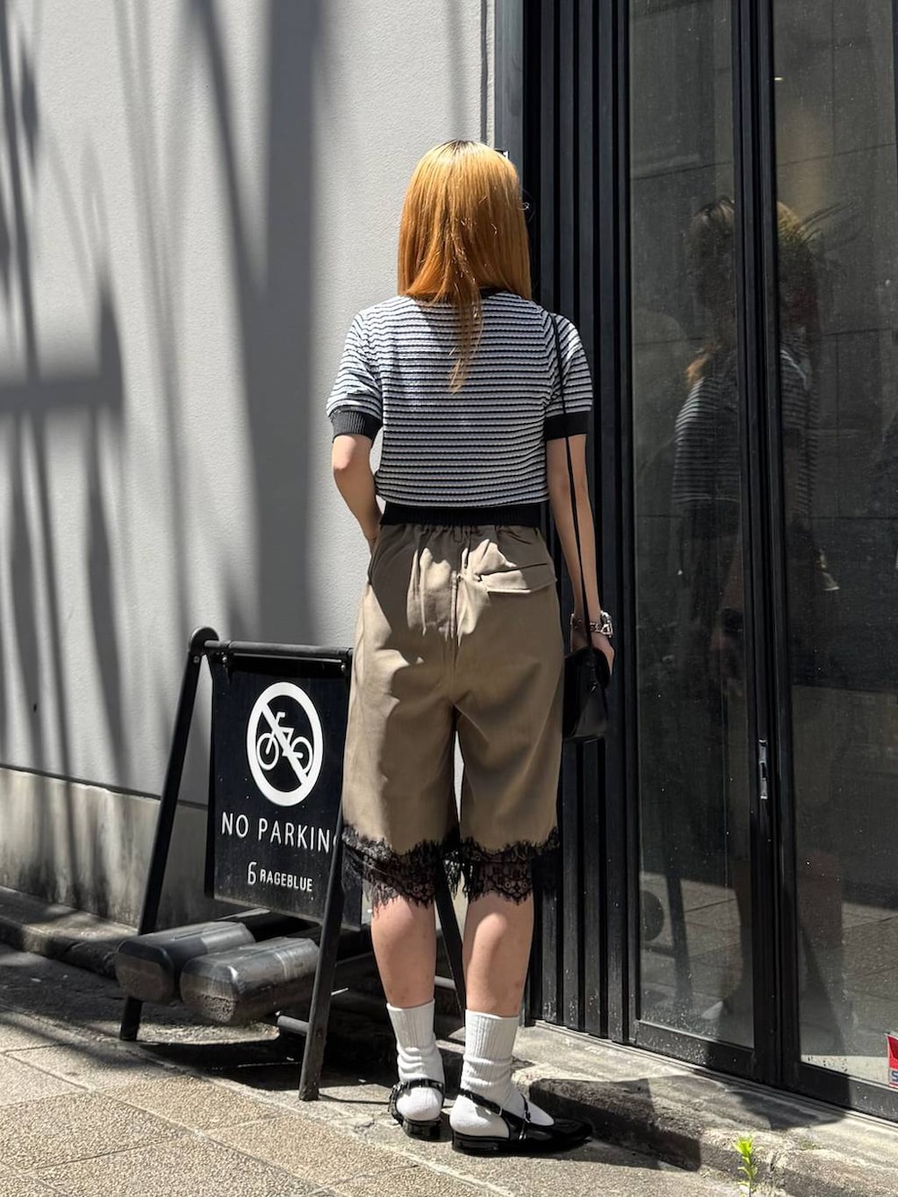 ブラック系のパンプス、グレー系のニット/セーター、ブラック系のショルダーバッグを着用したレディースの春コーディネートの7枚目の写真