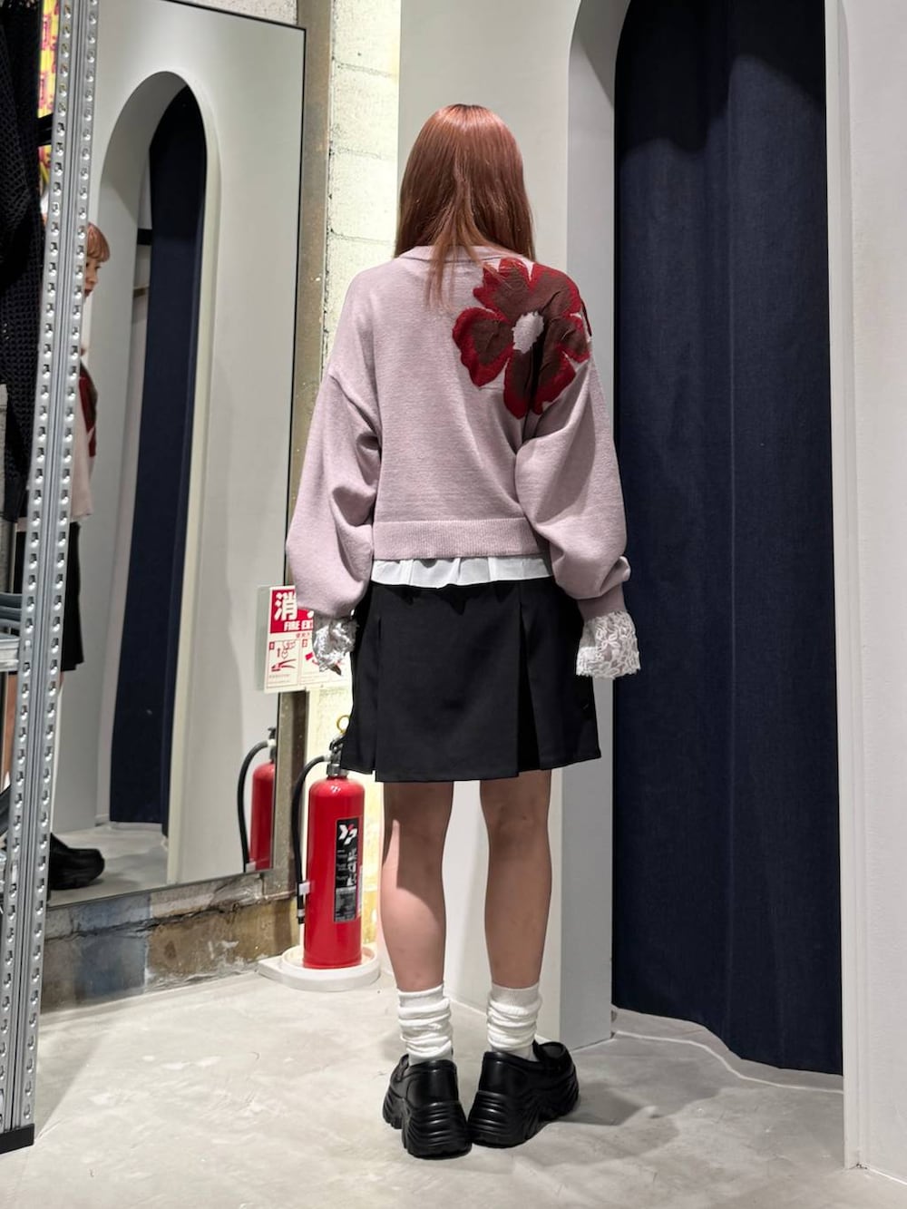 ホワイト系のTシャツ/カットソー、ピンク系のニット/セーター、ブラック系のスカートを着用したレディースの秋コーディネートの5枚目の写真