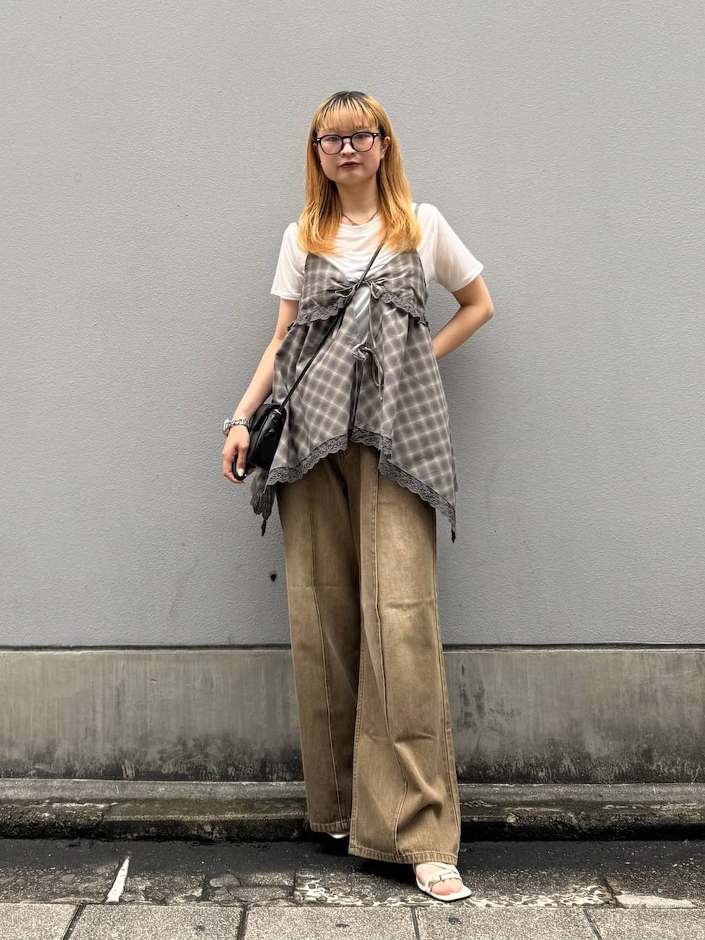 ホワイト系のTシャツ/カットソー、ブラック系のショルダーバッグ、ホワイト系のサンダルを着用したレディースの夏コーディネートの3枚目の写真