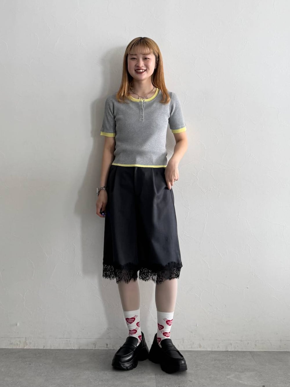 ブラック系のローファー、ブラック系のスラックス、グレー系のニット/セーターを着用したレディースの夏コーディネートの2枚目の写真