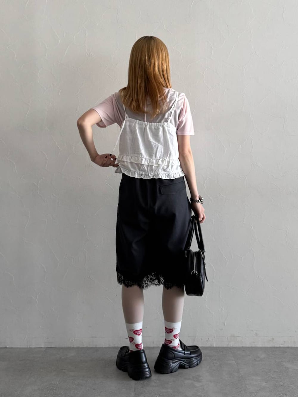 ブラック系のローファー、ブラック系のボストンバッグ、ピンク系のTシャツ/カットソーを着用したレディースの春コーディネートの6枚目の写真