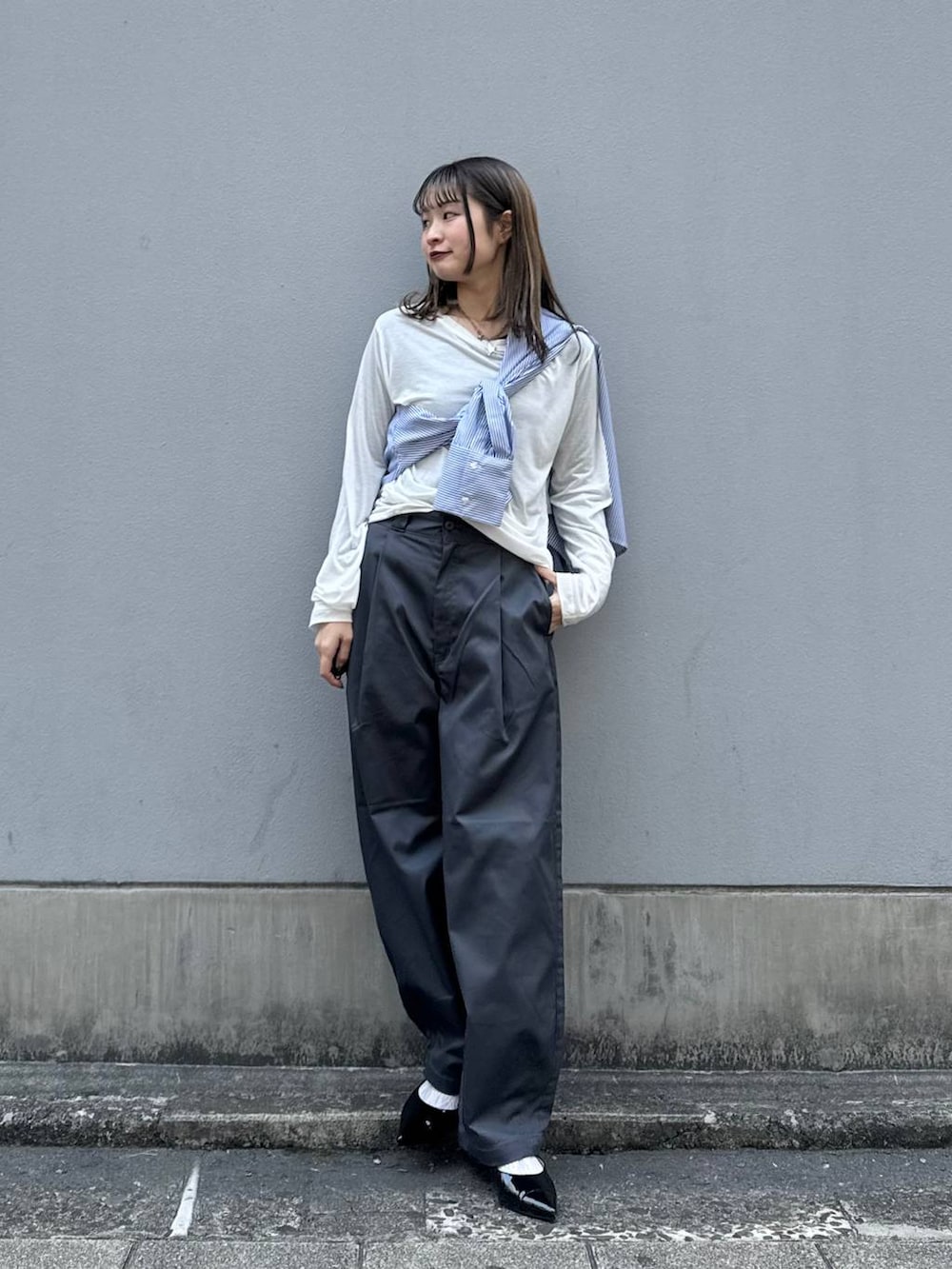 グレー系のチノパンツ、ブラック系のパンプス、ブルー系のシャツ/ブラウスを着用したレディースの春コーディネートの4枚目の写真