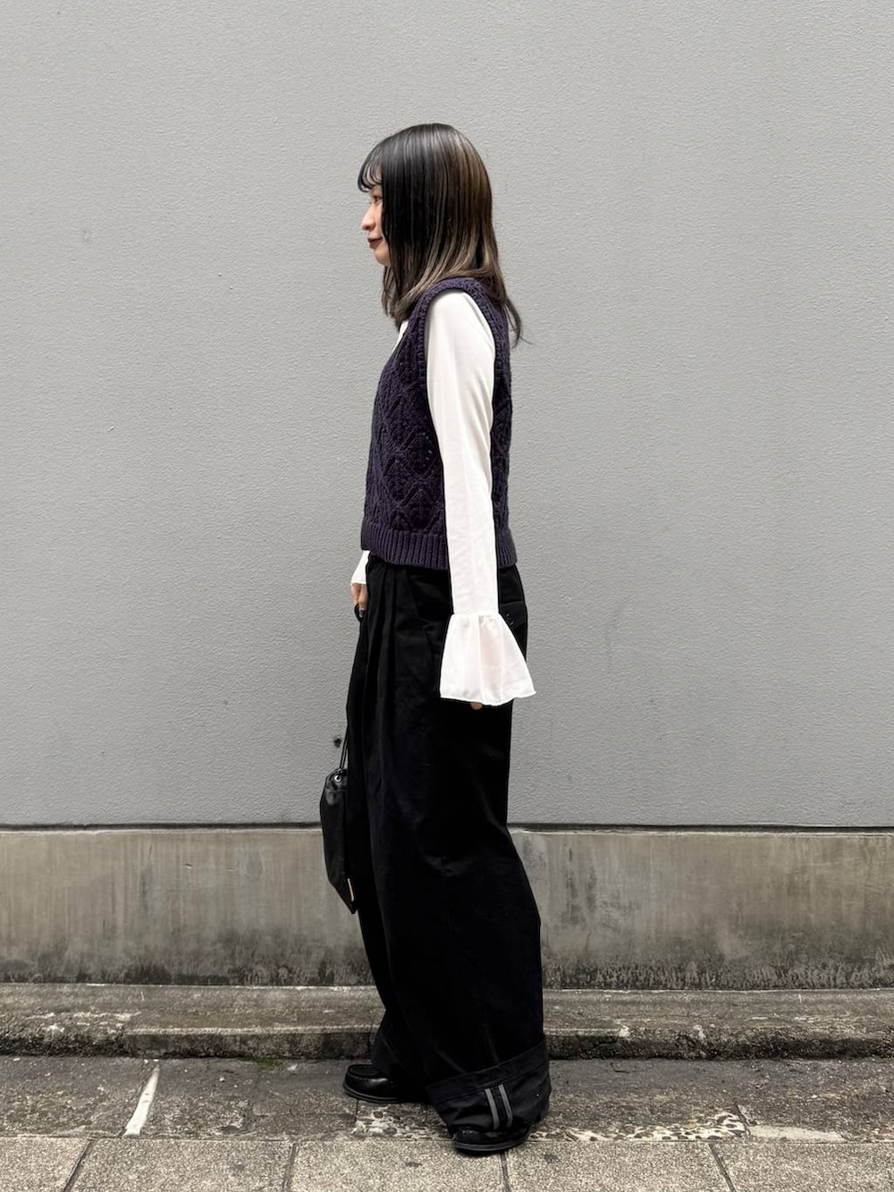 ブラック系のショルダーバッグ、ブラック系のチノパンツ、ホワイト系のTシャツ/カットソーを着用したレディースの春コーディネートの5枚目の写真