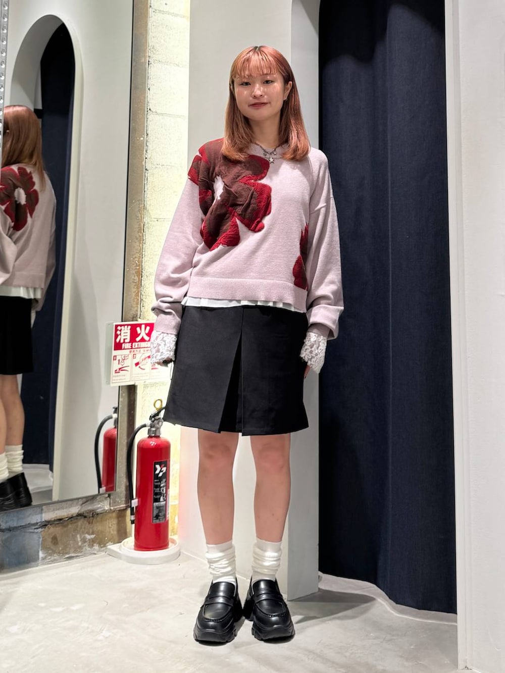 ホワイト系のTシャツ/カットソー、ピンク系のニット/セーター、ブラック系のスカートを着用したレディースの秋コーディネートの2枚目の写真