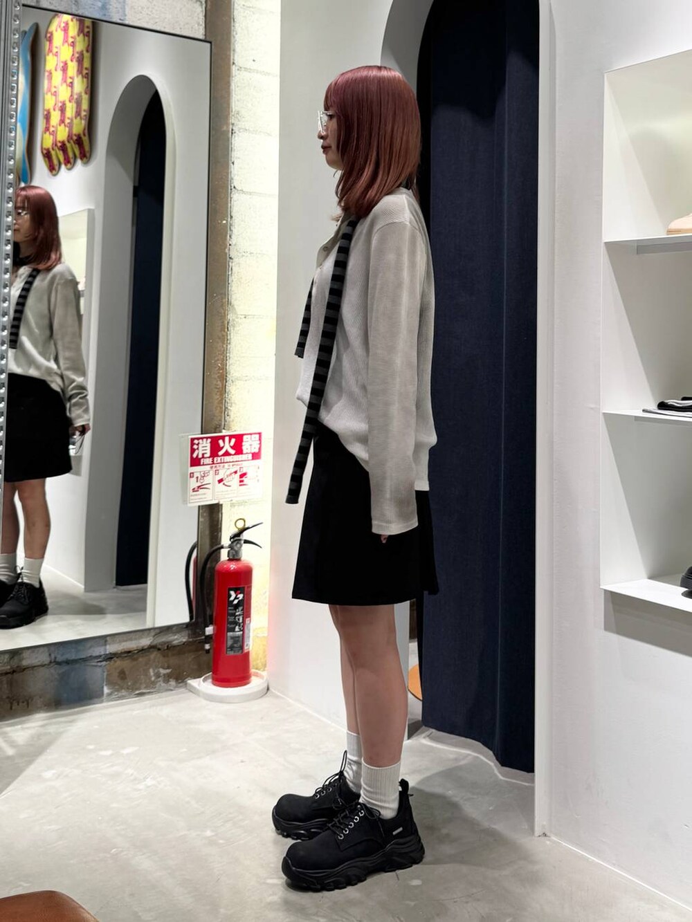 ブラック系のブーツ、ホワイト系のTシャツ/カットソー、ブラック系のニット/セーターを着用したレディースの秋コーディネートの5枚目の写真