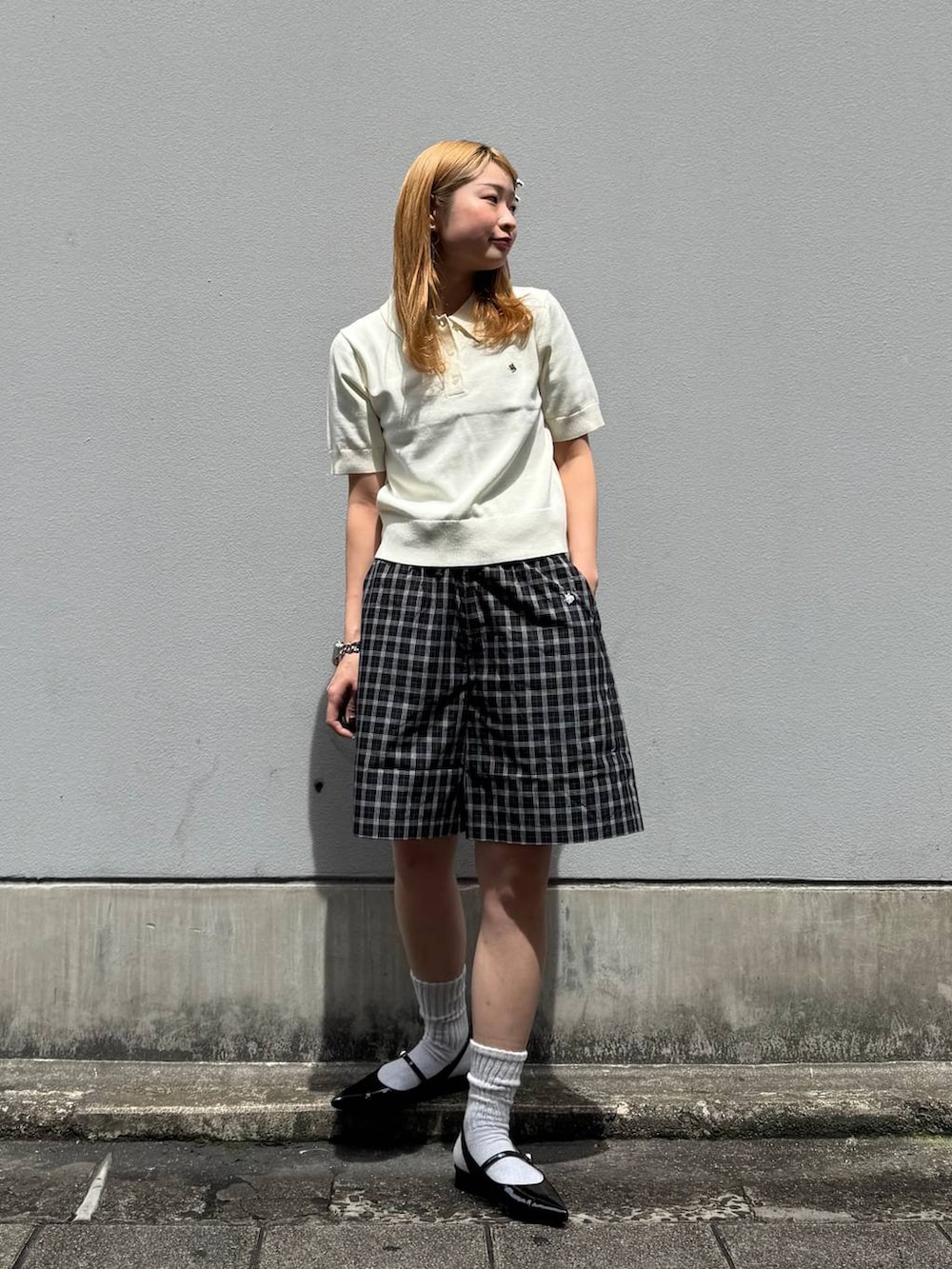 ブラック系のパンプス、ブラック系のその他パンツ、ホワイト系のポロシャツを着用したレディースの春コーディネートの4枚目の写真