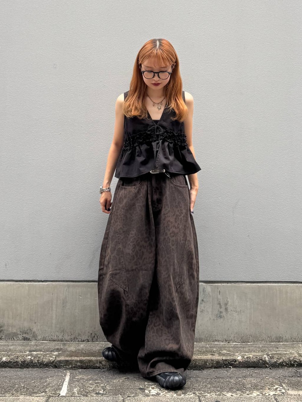 ブラウン系のデニムパンツ、ブラック系のベスト、ブラック系のベルトを着用したレディースの夏コーディネートの4枚目の写真
