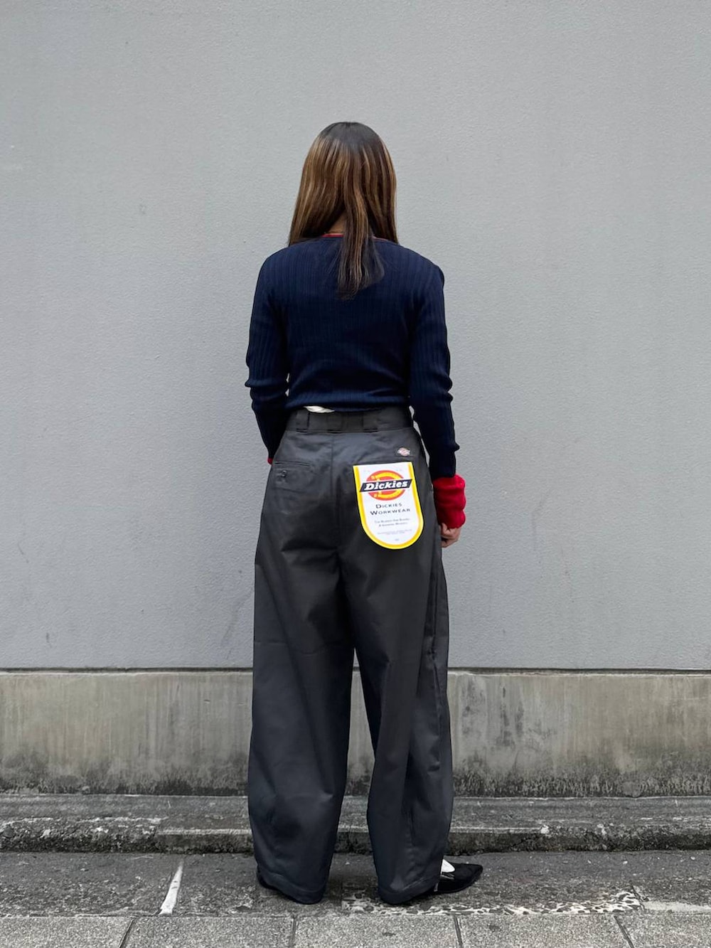 グレー系のチノパンツ、ブラック系のパンプス、ブルー系のニット/セーターを着用したレディースの春コーディネートの6枚目の写真