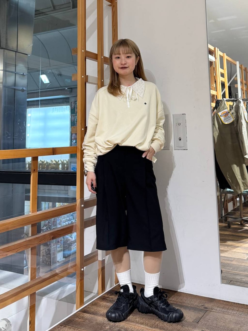 ホワイト系のスウェット、ブラック系のスラックスを着用したレディースの春コーディネートの3枚目の写真