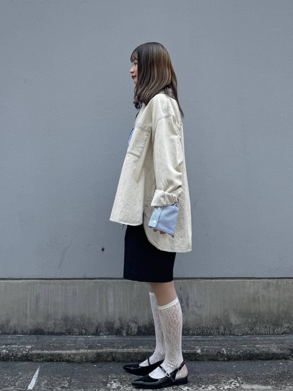 ブラック系のパンプス、ブラック系のスラックス、ブルー系のシャツ/ブラウスを着用したレディースの春コーディネートの6枚目の写真