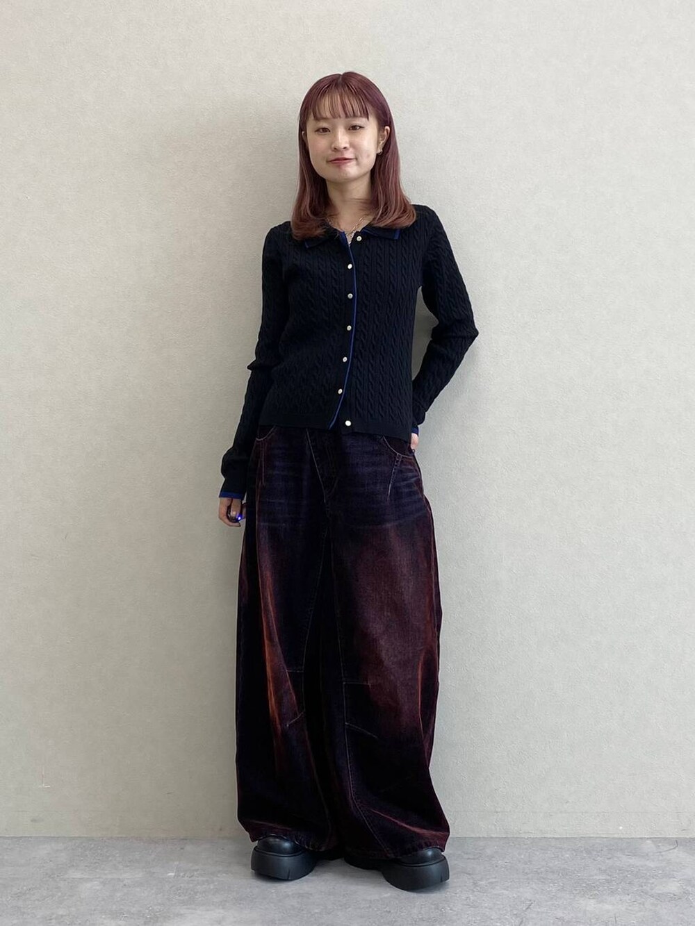 レッド系のデニムパンツ、ブラック系のニット/セーターを着用したレディースの秋コーディネートの3枚目の写真