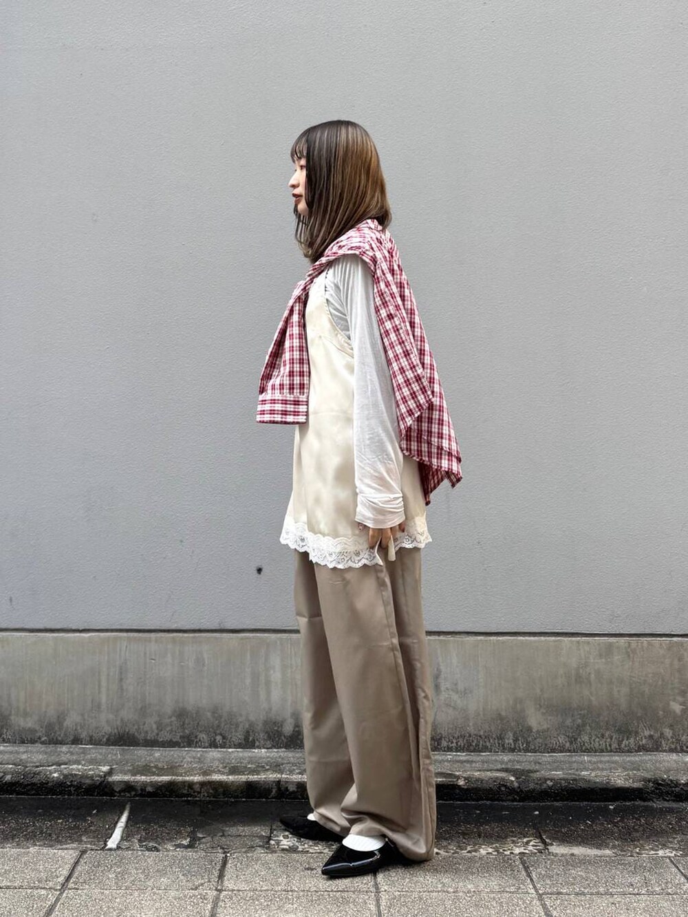 ブラック系のパンプス、ホワイト系のキャミソール、ベージュ系のスラックスを着用したレディースの春コーディネートの7枚目の写真