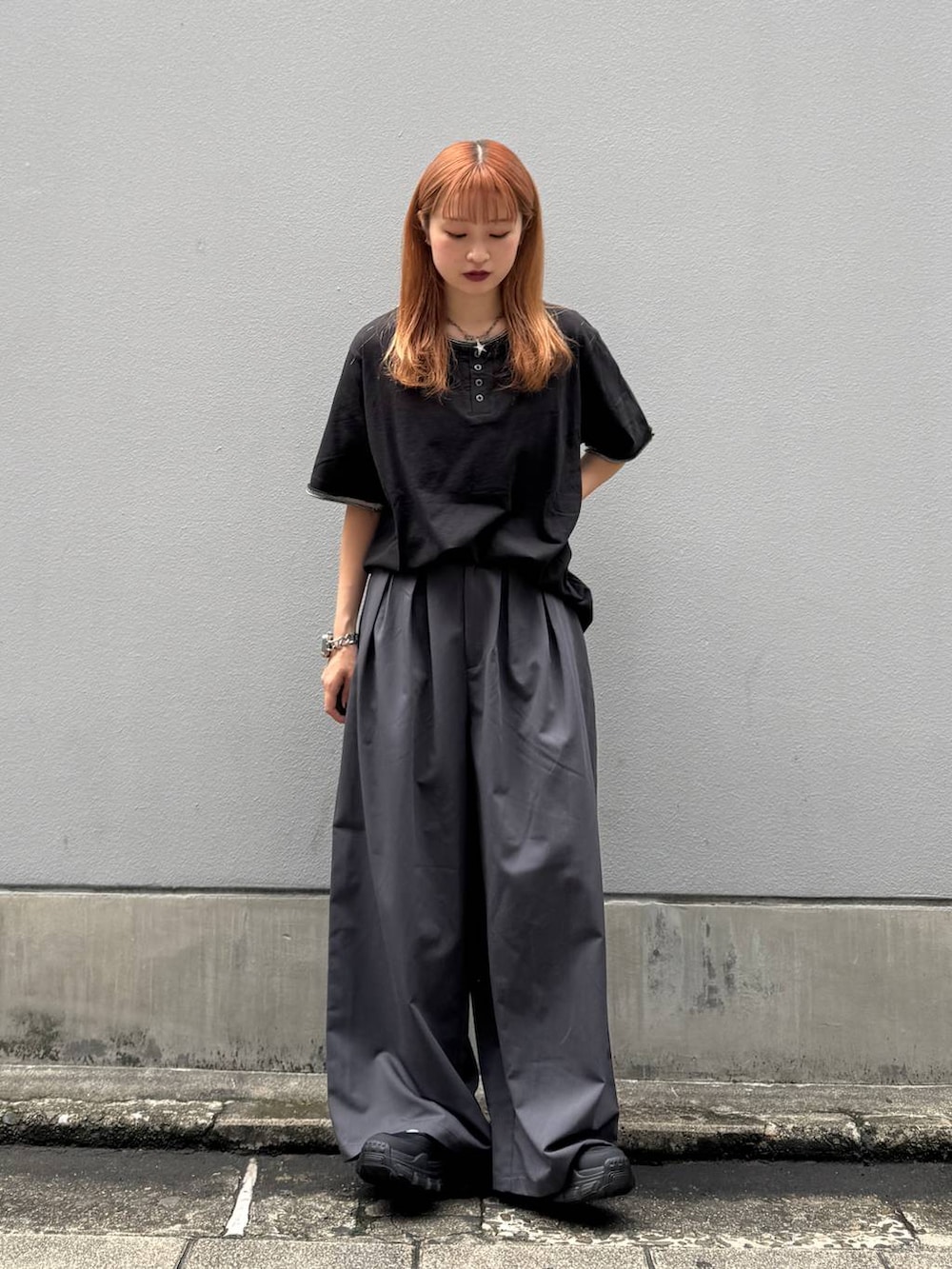 ブラック系のTシャツ/カットソー、グレー系のスラックス、ブラック系のサンダルを着用したレディースの夏コーディネートの2枚目の写真
