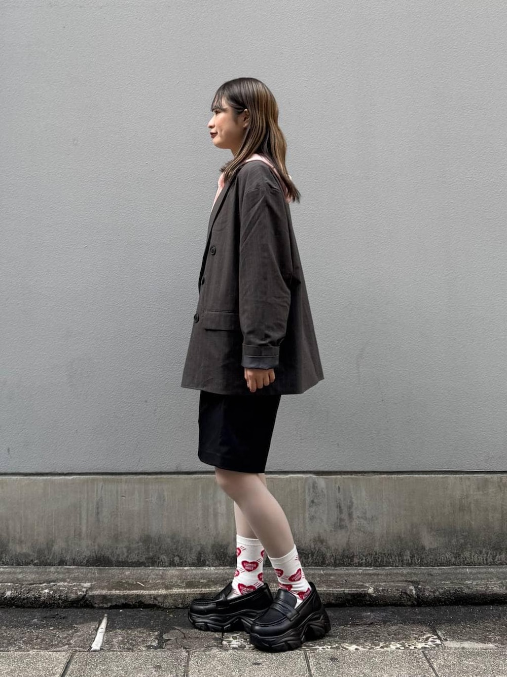 ブラック系のテーラードジャケット、ブラック系のローファー、ブラック系のスラックスを着用したレディースの春コーディネートの5枚目の写真