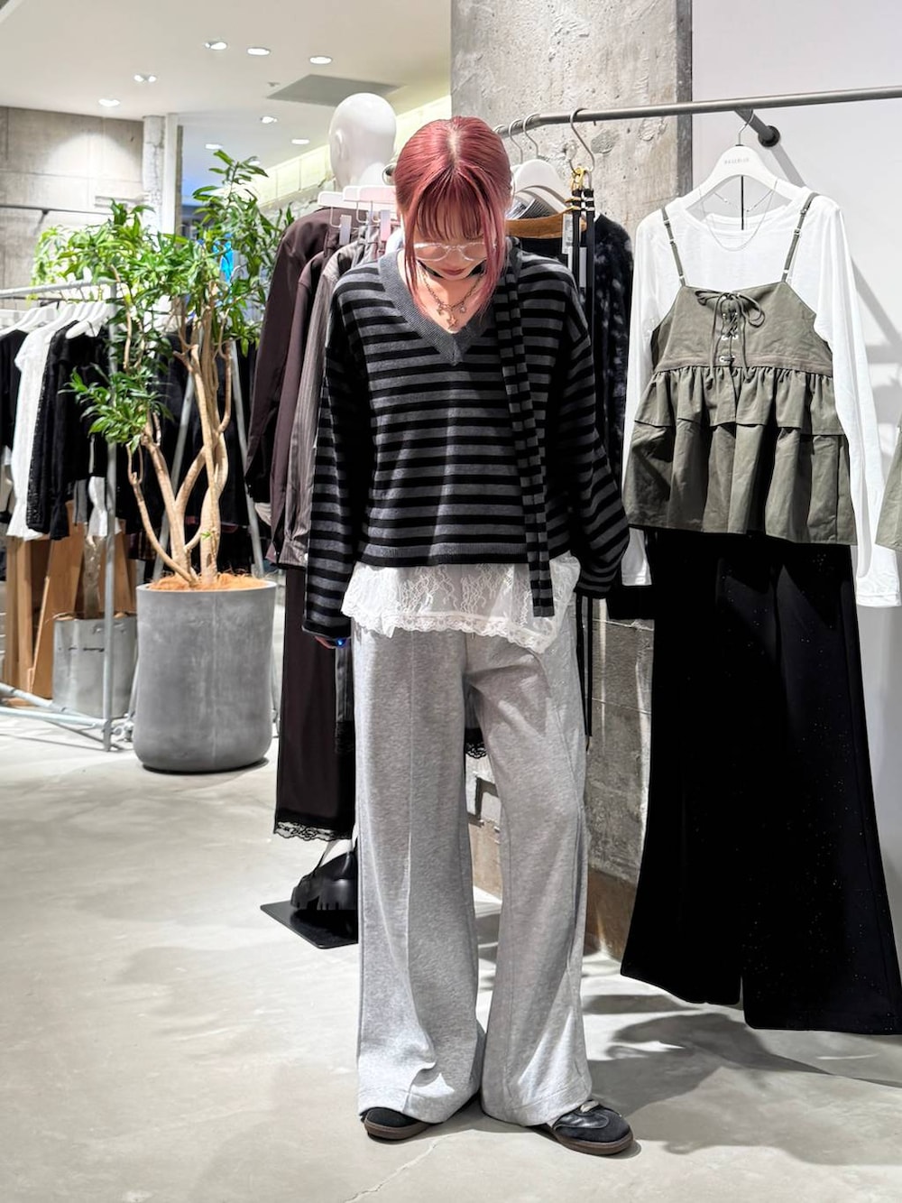 ホワイト系のTシャツ/カットソー、ブラック系のニット/セーター、グレー系のスウェットパンツを着用したレディースの秋コーディネートの3枚目の写真
