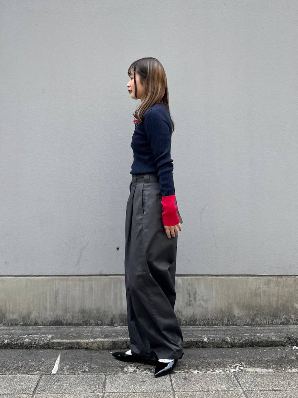 グレー系のチノパンツ、ブラック系のパンプス、ブルー系のニット/セーターを着用したレディースの春コーディネートの5枚目の写真