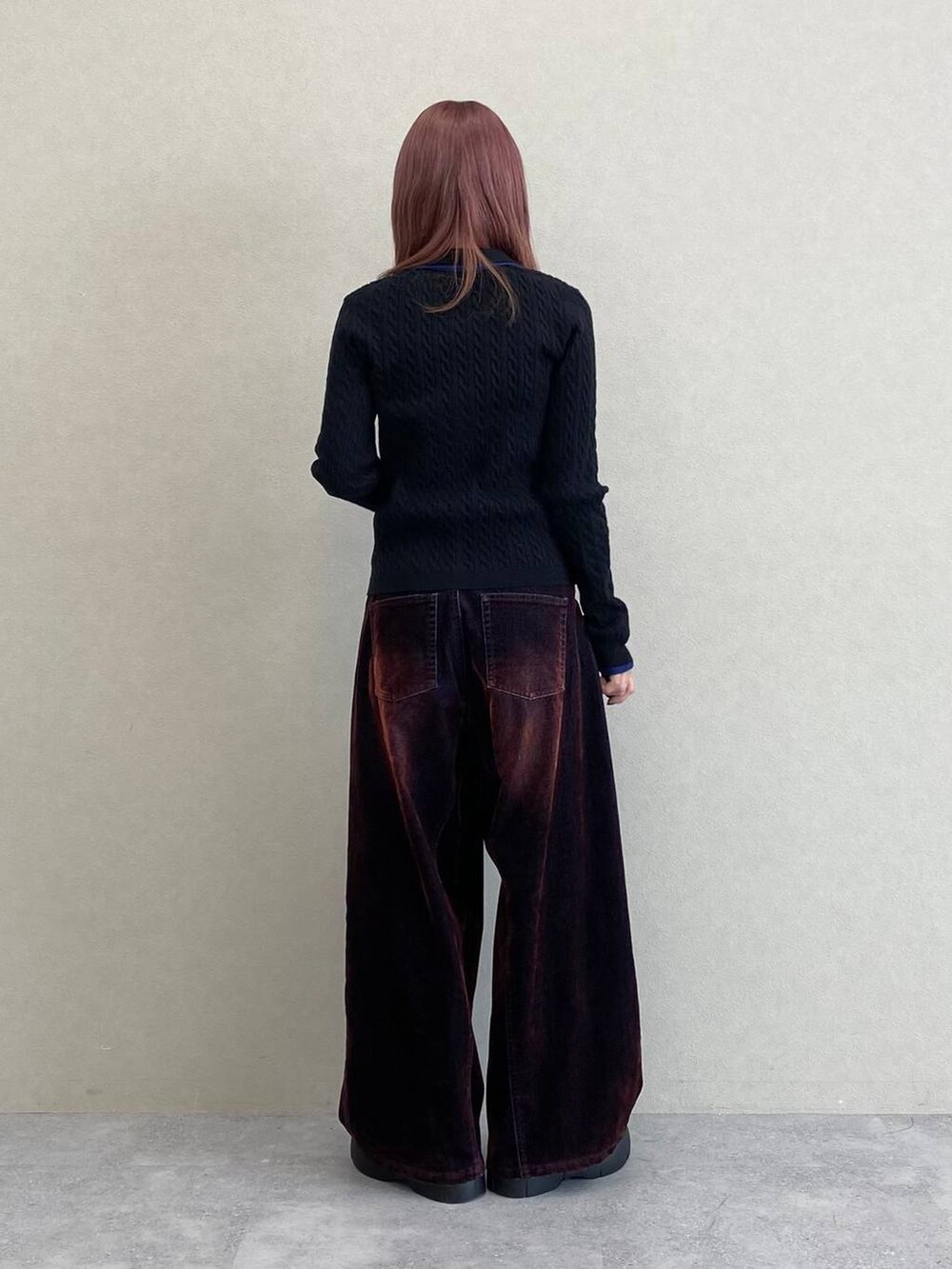 レッド系のデニムパンツ、ブラック系のニット/セーターを着用したレディースの秋コーディネートの6枚目の写真